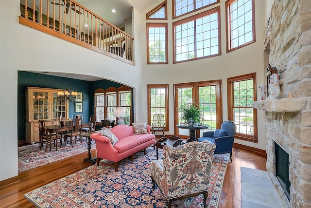 5318 Westerham St, Fulshear, TX 77441 - living room featuring wood finished floors, a fireplace, a chandelier, and a high ceiling