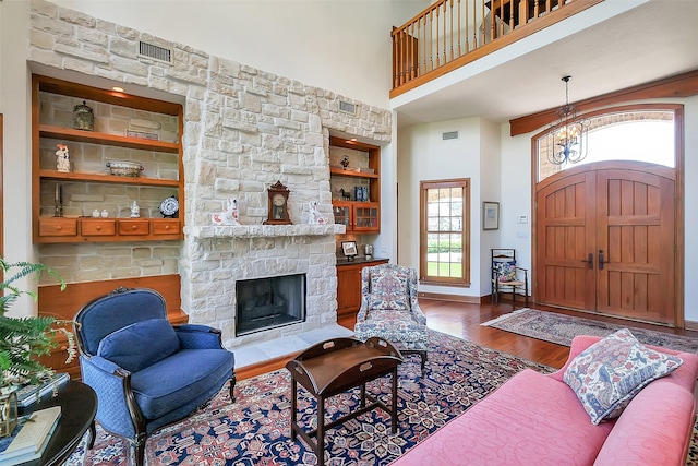 5318 Westerham St, Fulshear, TX 77441 - living room featuring wood finished floors, a high ceiling, built in shelves, a fireplace, and baseboards