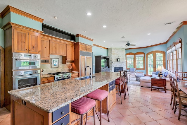 5318 Westerham St, Fulshear, TX 77441 - kitchen featuring crown molding, a sink, a ceiling fan, open floor plan, and paneled built in refrigerator