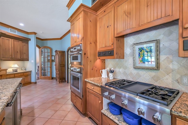 5318 Westerham St, Fulshear, TX 77441 - kitchen with appliances with stainless steel finishes, crown molding, light tile patterned floors, tasteful backsplash, and light stone countertops