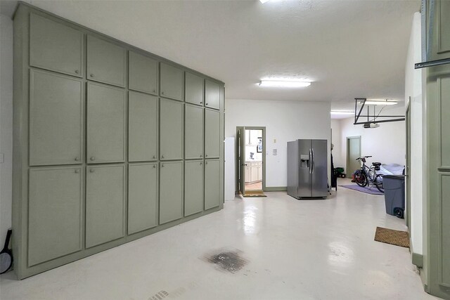 5318 Westerham St, Fulshear, TX 77441 - garage featuring stainless steel fridge with ice dispenser and a garage door opener
