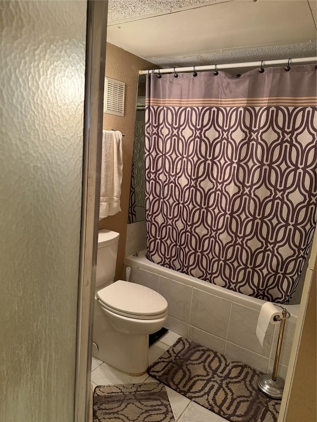 2120 El Paseo St Unit 209, Houston, TX 77054 - bathroom with tiled shower / bath combo, tile patterned flooring, toilet, and a textured wall