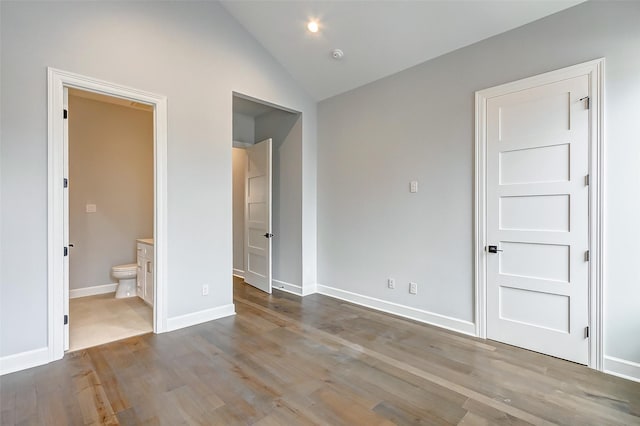 6522 Westview Dr, Houston, TX 77055 - unfurnished bedroom with wood finished floors, lofted ceiling, ensuite bath, and baseboards