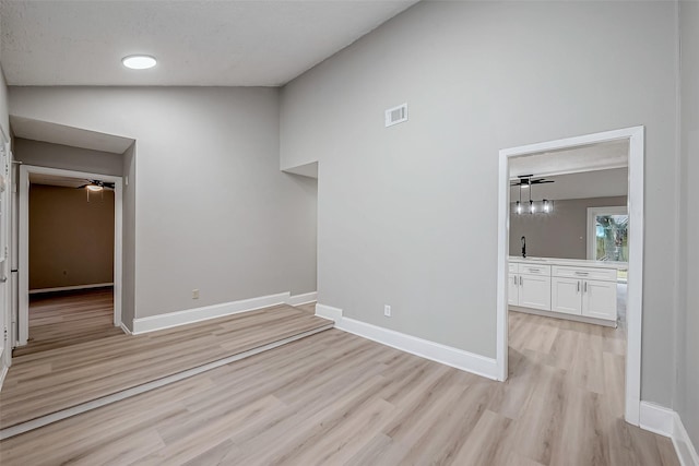 23227 Pine Post Ln, Spring, TX 77373 - unfurnished room with light wood-type flooring, ceiling fan, a sink, baseboards, and vaulted ceiling