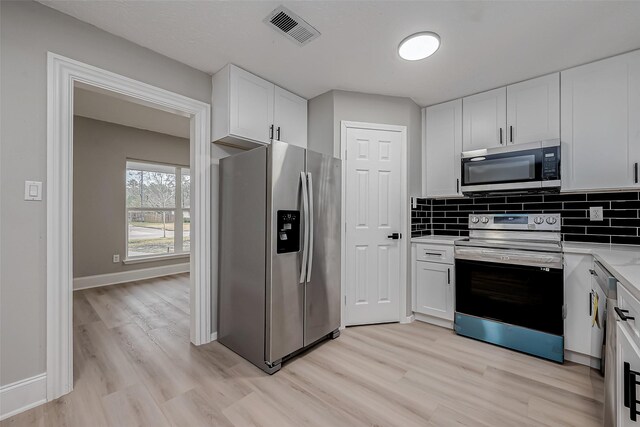 23227 Pine Post Ln, Spring, TX 77373 - kitchen featuring stainless steel appliances, light wood-type flooring, white cabinetry, and light countertops