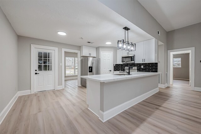 23227 Pine Post Ln, Spring, TX 77373 - kitchen featuring appliances with stainless steel finishes, light countertops, light wood-style floors, and white cabinetry