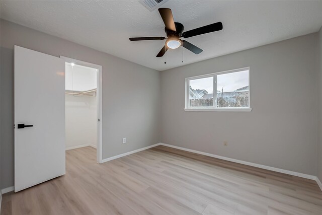 23227 Pine Post Ln, Spring, TX 77373 - unfurnished bedroom with light wood finished floors, a walk in closet, baseboards, and a closet