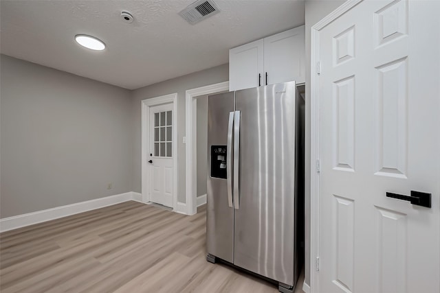 23227 Pine Post Ln, Spring, TX 77373 - kitchen featuring stainless steel fridge with ice dispenser, light wood finished floors, baseboards, white cabinetry, and a textured ceiling