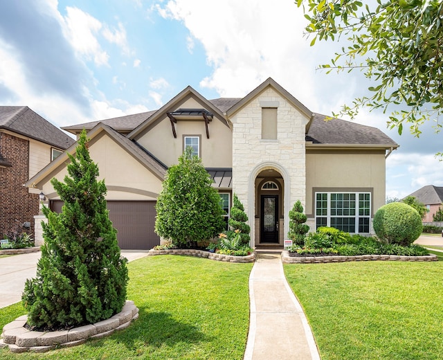 4423 Sterling Heights Ln, Sugar Land, TX 77479 - french country style house with stucco siding, concrete driveway, a front lawn, an attached garage, and stone siding