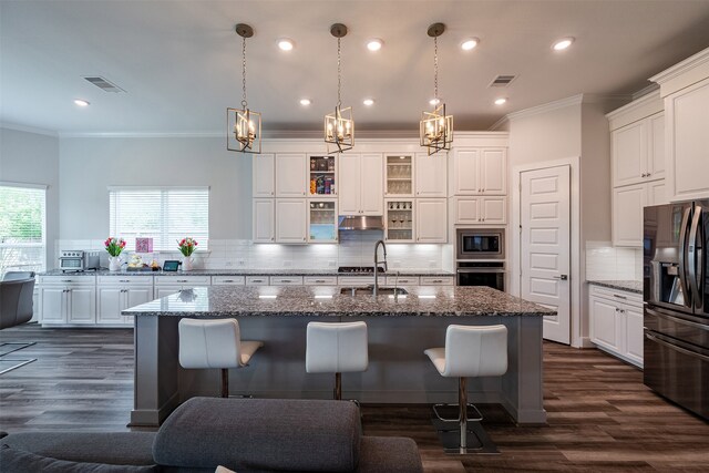 4423 Sterling Heights Ln, Sugar Land, TX 77479 - kitchen featuring appliances with stainless steel finishes, ornamental molding, a breakfast bar area, a chandelier, and backsplash