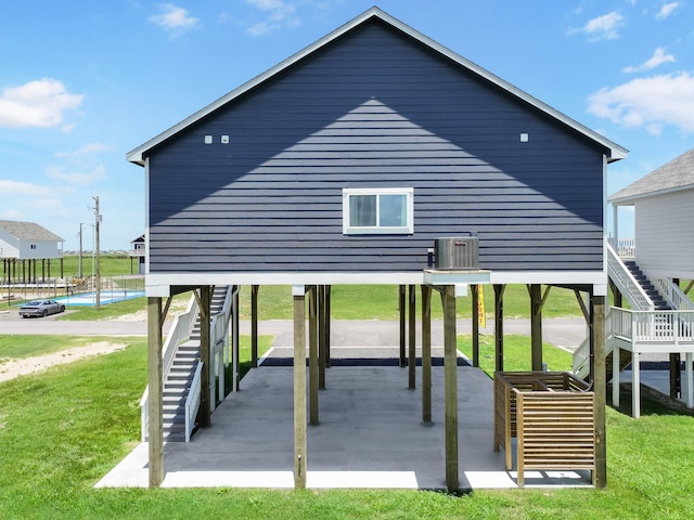 1025 Sunset Cir W, Crystal Beach, TX 77650 - back of house featuring stairs and a lawn