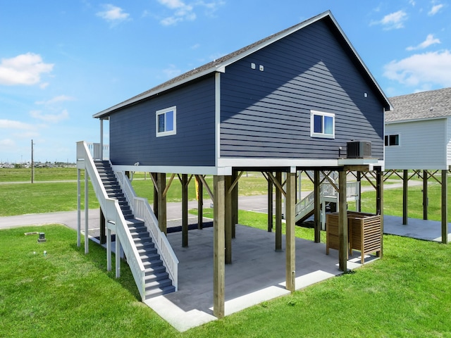 1025 Sunset Cir W, Crystal Beach, TX 77650 - rear view of property featuring stairs, a patio area, and a lawn