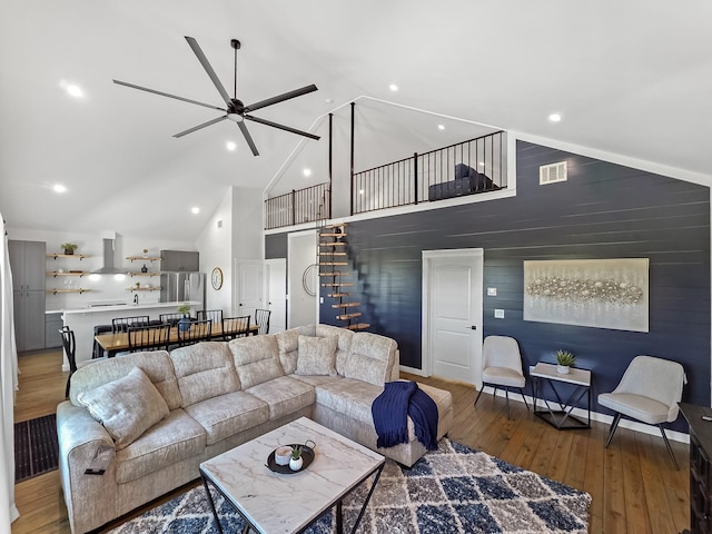 1025 Sunset Cir W, Crystal Beach, TX 77650 - living area featuring wood-type flooring, a ceiling fan, high vaulted ceiling, recessed lighting, and stairs
