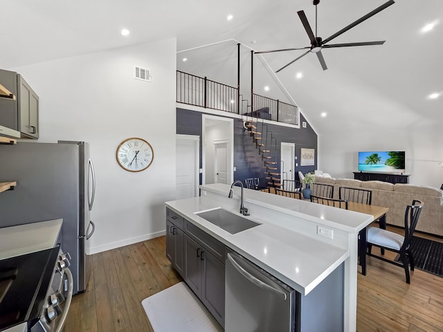 1025 Sunset Cir W, Crystal Beach, TX 77650 - kitchen featuring appliances with stainless steel finishes, a ceiling fan, open floor plan, dark wood-style floors, and light countertops