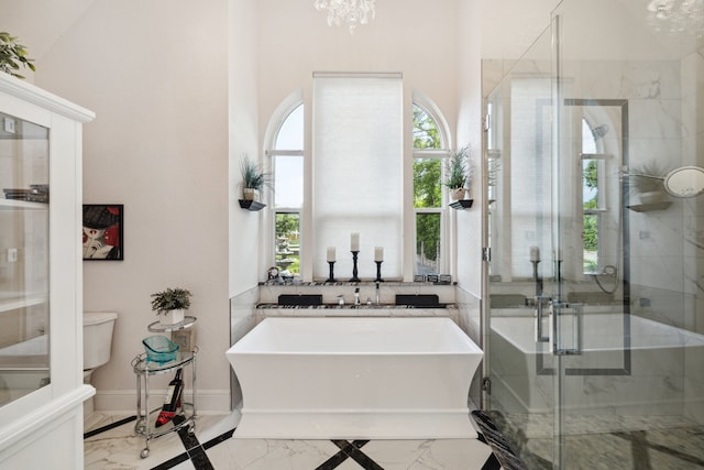 1917 Anchor Way, Dickinson, TX 77539 - bathroom with marble tiled floors, a freestanding tub, a shower stall, a chandelier, and baseboards
