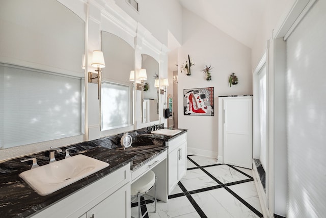 1917 Anchor Way, Dickinson, TX 77539 - bathroom featuring marble finish flooring, vaulted ceiling, double vanity, baseboards, and inlaid floor details