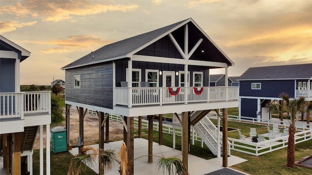 1025 Sunset Cir W, Crystal Beach, TX 77650 - view of front of house featuring board and batten siding, a patio area, a carport, and stairs