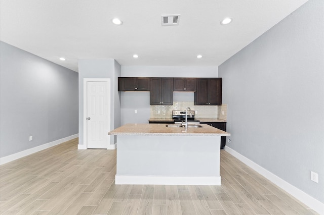 4534 Maggie St, Houston, TX 77051 - kitchen with a sink, light countertops, dark brown cabinetry, tasteful backsplash, and light wood-type flooring