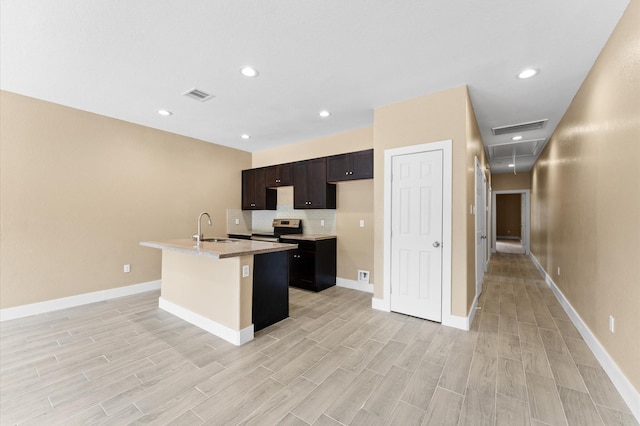 4534 Maggie St, Houston, TX 77051 - kitchen featuring stainless steel electric stove, a sink, an island with sink, light wood finished floors, and recessed lighting