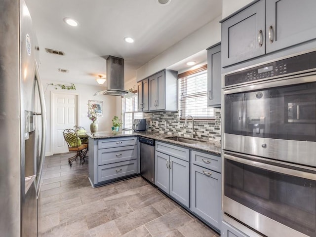 674 Ravensworth Dr, Conroe, TX 77302 - kitchen featuring appliances with stainless steel finishes, gray cabinetry, a sink, a peninsula, and recessed lighting