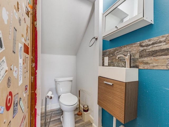 674 Ravensworth Dr, Conroe, TX 77302 - bathroom with toilet, wood finished floors, vaulted ceiling, and vanity