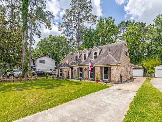 674 Ravensworth Dr, Conroe, TX 77302 - cape cod house featuring a front lawn, brick siding, an outdoor structure, and a garage