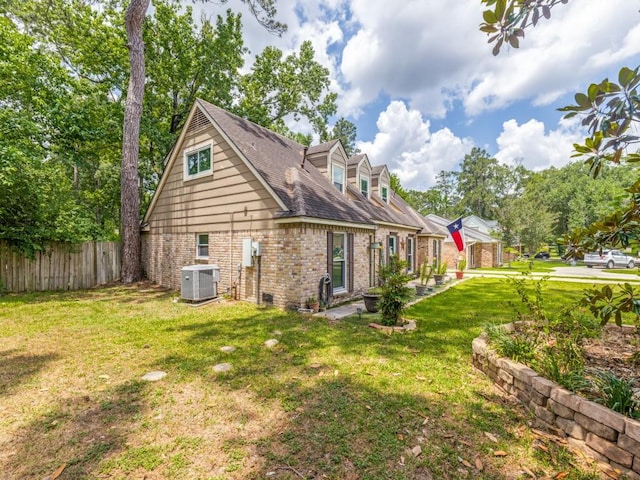 674 Ravensworth Dr, Conroe, TX 77302 - view of property exterior with central air condition unit, brick siding, and a patio