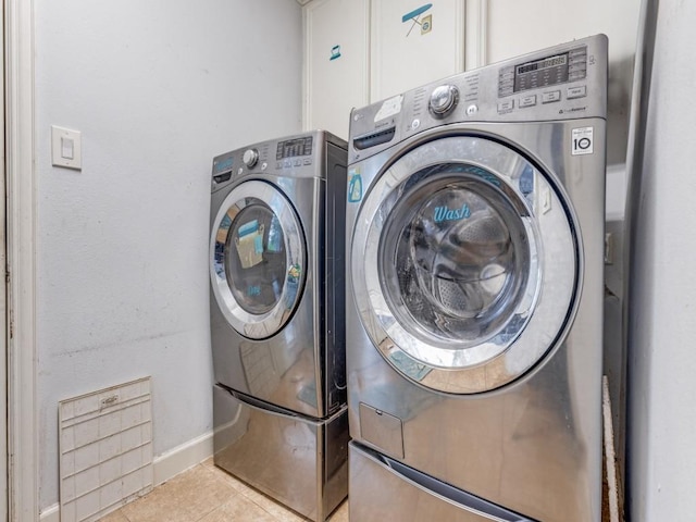 674 Ravensworth Dr, Conroe, TX 77302 - laundry area with washing machine and clothes dryer, tile patterned floors, and baseboards