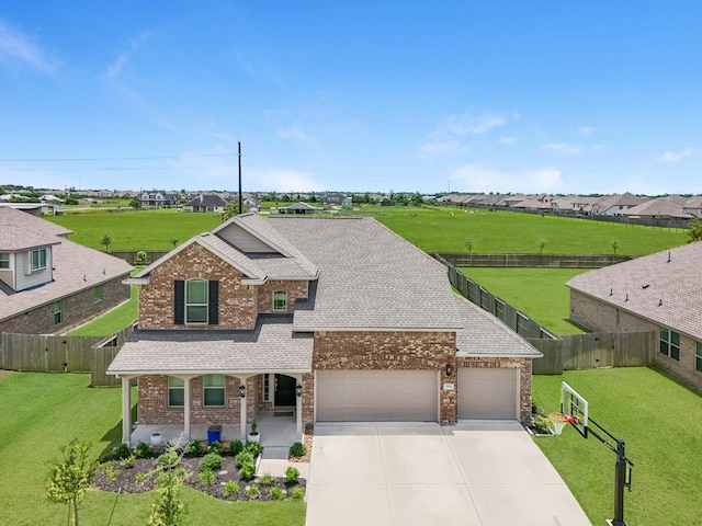 15010 Lake Shore Ave, Mont Belvieu, TX 77523 - view of front of property with a porch, an attached garage, brick siding, a shingled roof, and concrete driveway