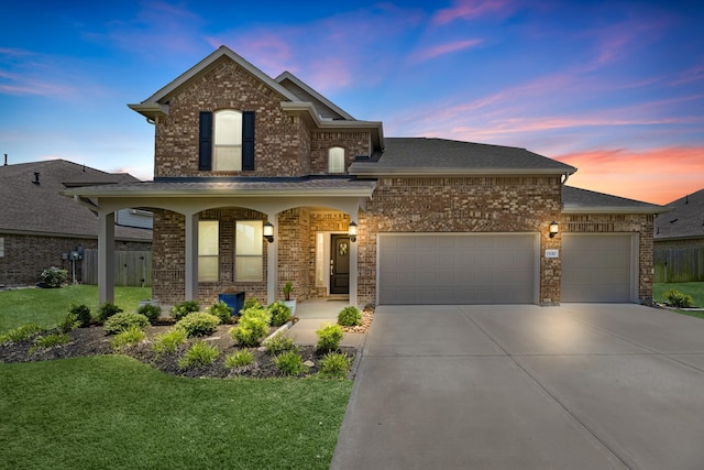 15010 Lake Shore Ave, Mont Belvieu, TX 77523 - traditional home with driveway, brick siding, an attached garage, and a porch