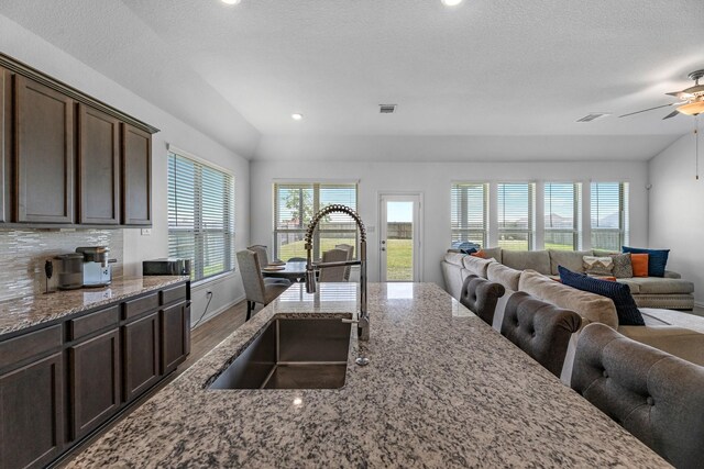 15010 Lake Shore Ave, Mont Belvieu, TX 77523 - kitchen with a sink, open floor plan, lofted ceiling, ceiling fan, and dark brown cabinets