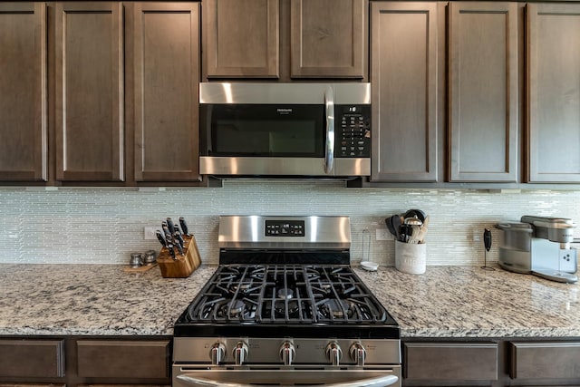 15010 Lake Shore Ave, Mont Belvieu, TX 77523 - kitchen with appliances with stainless steel finishes, backsplash, and dark brown cabinets