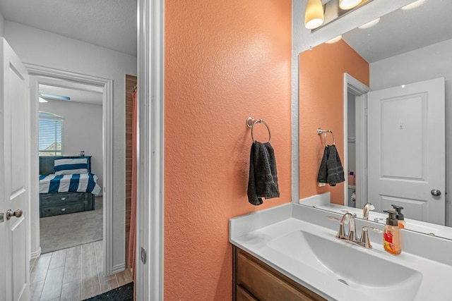 15010 Lake Shore Ave, Mont Belvieu, TX 77523 - ensuite bathroom with a textured wall, vanity, wood finished floors, and toilet