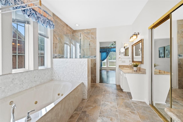 1711 Alcorn Bayou Dr, Sugar Land, TX 77479 - full bath featuring a tile shower, a tub with jets, vanity, and stone tile flooring