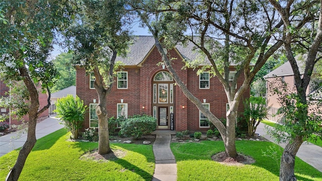 1711 Alcorn Bayou Dr, Sugar Land, TX 77479 - view of front of property with brick siding, a front yard, roof with shingles, and driveway