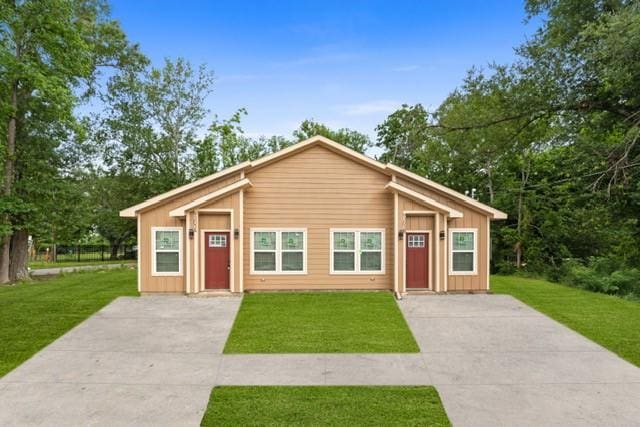 9303 Firnat St, Houston, TX 77016 - view of front of home with concrete driveway, a front lawn, and board and batten siding