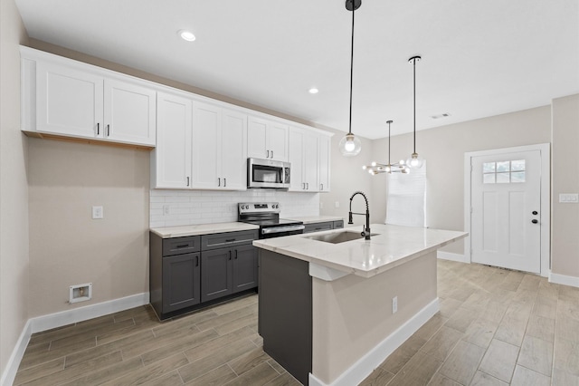 9303 Firnat St, Houston, TX 77016 - kitchen with appliances with stainless steel finishes, a sink, gray cabinetry, baseboards, and light wood-type flooring