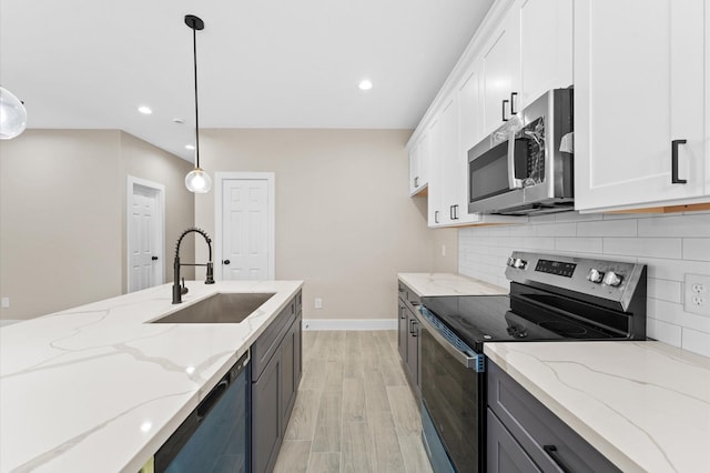 9303 Firnat St, Houston, TX 77016 - kitchen with stainless steel appliances, a sink, decorative backsplash, baseboards, and light wood-type flooring