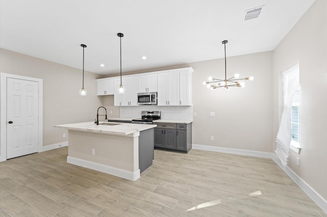 9303 Firnat St, Houston, TX 77016 - kitchen featuring stainless steel appliances, a sink, a chandelier, decorative backsplash, and gray cabinets