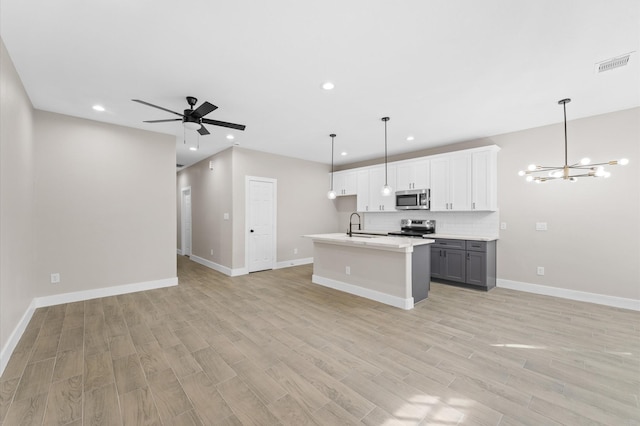 9303 Firnat St, Houston, TX 77016 - kitchen with appliances with stainless steel finishes, open floor plan, a chandelier, recessed lighting, and light wood-type flooring