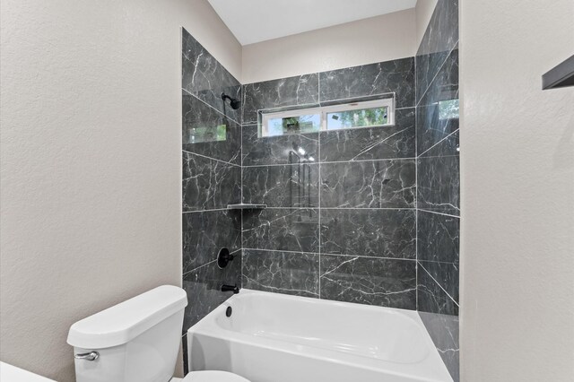 9303 Firnat St, Houston, TX 77016 - full bathroom with toilet, washtub / shower combination, and a textured wall