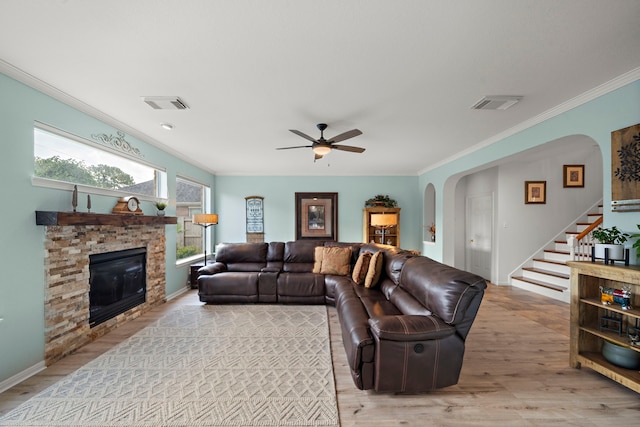 20306 Silverwood Trl, Cypress, TX 77433 - living room with arched walkways, crown molding, light wood-type flooring, stairs, and a stone fireplace