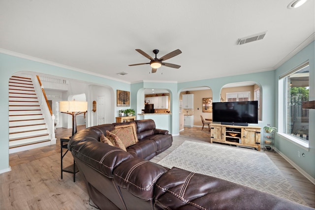 20306 Silverwood Trl, Cypress, TX 77433 - living area featuring arched walkways, ceiling fan, stairway, baseboards, and ornamental molding