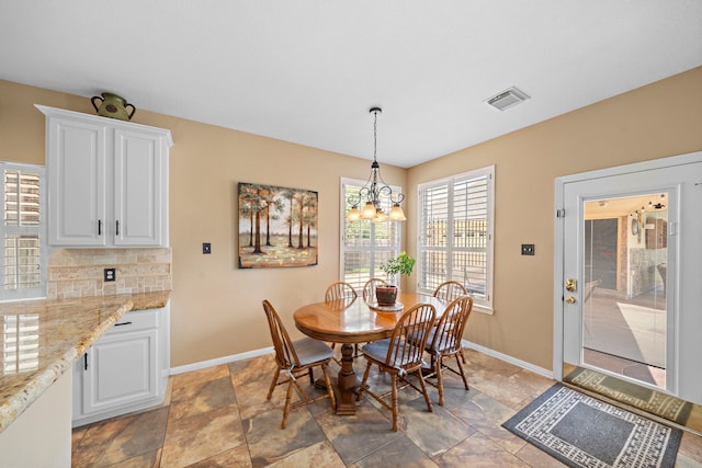 20306 Silverwood Trl, Cypress, TX 77433 - dining area featuring baseboards, a chandelier, and light stone finish flooring
