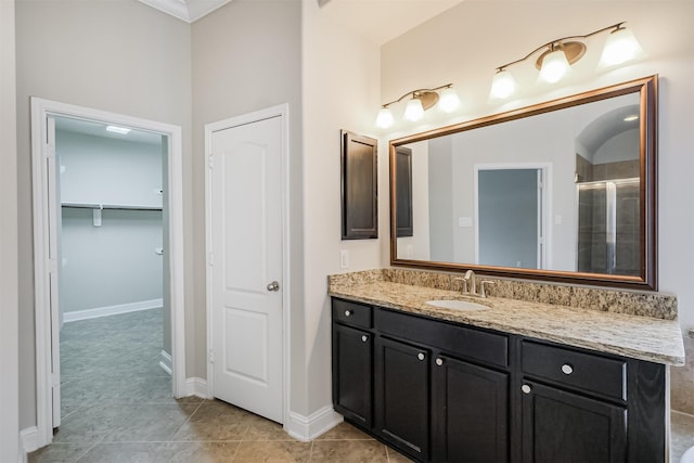 13918 Twisting Ivy Ln, Cypress, TX 77429 - full bathroom featuring vanity, a tile shower, a walk in closet, baseboards, and tile patterned floors
