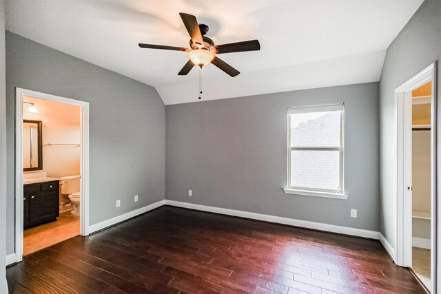 13918 Twisting Ivy Ln, Cypress, TX 77429 - unfurnished bedroom with lofted ceiling, dark wood finished floors, baseboards, ensuite bathroom, and a ceiling fan