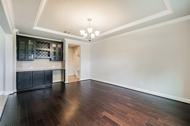 13918 Twisting Ivy Ln, Cypress, TX 77429 - unfurnished living room with a raised ceiling, dark wood-style flooring, a chandelier, a dry bar, and ornamental molding