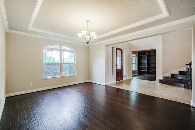 13918 Twisting Ivy Ln, Cypress, TX 77429 - unfurnished room featuring a tray ceiling, a chandelier, stairway, a textured ceiling, and wood finished floors