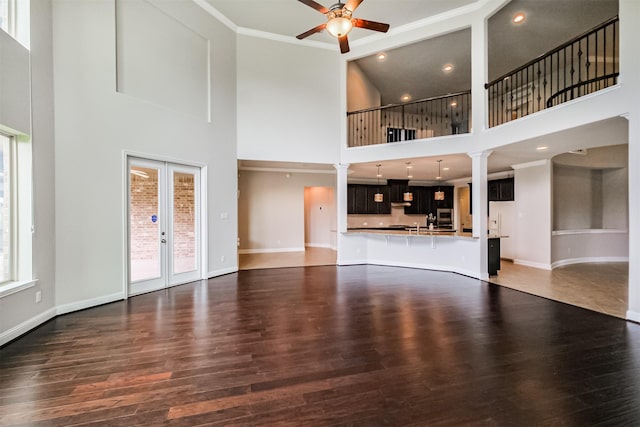 13918 Twisting Ivy Ln, Cypress, TX 77429 - unfurnished living room featuring a towering ceiling, a ceiling fan, dark wood-type flooring, french doors, and baseboards