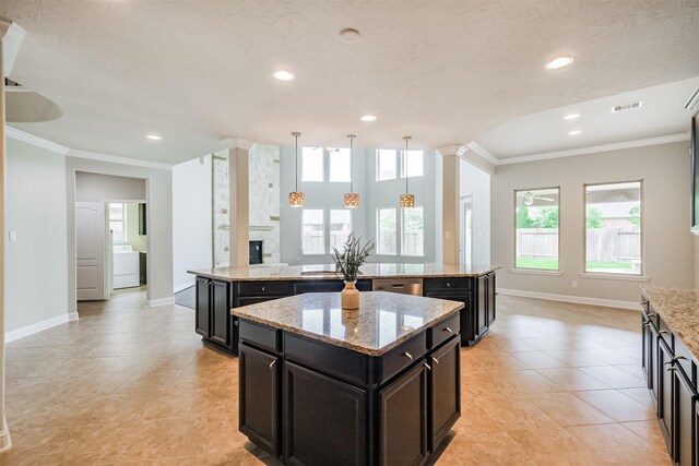 13918 Twisting Ivy Ln, Cypress, TX 77429 - kitchen featuring a spacious island, washer / dryer, ornamental molding, baseboards, and decorative light fixtures